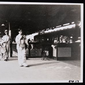 Women in kimonos, men in European clothing, children at the train station