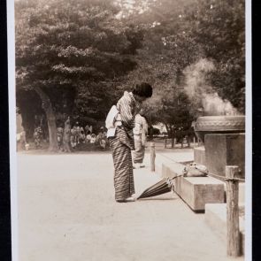 A csíkos kimonós hölgy az Óriás Buddha előtt imádkozik