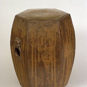 Drum chair with a hexagonal cover and mask-shaped handle holes