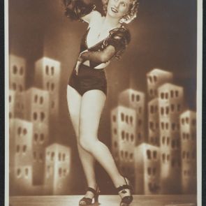 Flóra Dessewffy in a T-shirt on the podium, in front of a big city backdrop