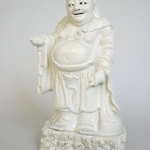 Budai standing on a rock with a sack and a rosary