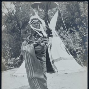 Indian chief Baktay Ervin with a peace pipe in front of the tent