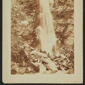 Unknown photographer: Waterfall, with three people on the rocks in front of it