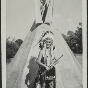 Baktay in feather decoration in front of his tent