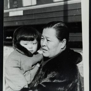 Életkép: Vonat előtt álló nő kisgyermekével