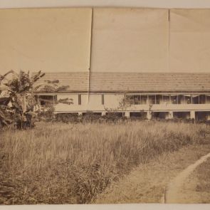 A long house standing on legs, with gentlemen and a lady