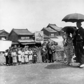 Japanese children stare at the foreign photographer; in the background a toothpaste advertisement