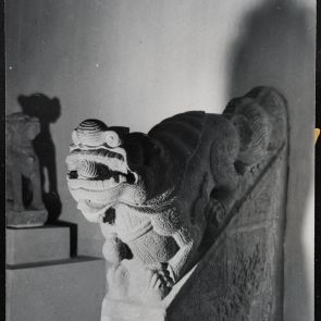 Fekete-fehér fotó mitikus oroszlánt ábrázoló épületdíszről