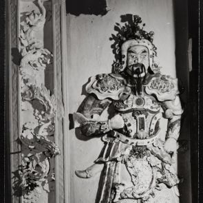 Fekete-fehér fotó buddhista házikápolna stukkó kapuőréről