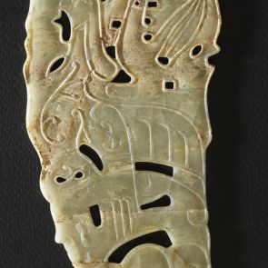 Carving with openwork decoration, showing a human figure with a tall headdress