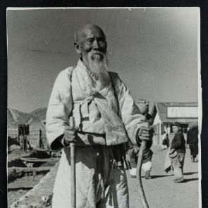 Életkép: Koreai szakállas, idős férfi bottal, utcarészlet