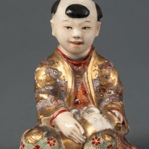 Okimono: seated Chinese boy (karako) holding a paper roll