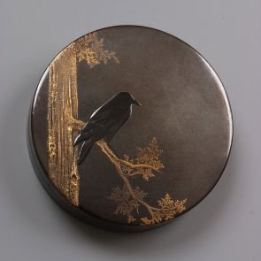 Round, flat box, its lid decorated with a bird sitting on a branch