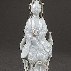 The bodhisattva Guanyin sitting on lotuses, with a bird on her right and a vase on her left
