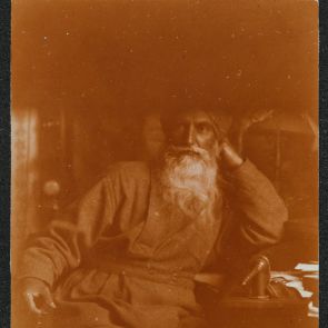Self-portrait at desk, half in shade