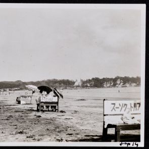 Három háttal ülő alak a napernyők alatt