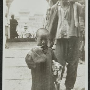 Life on the street in front of the main gate: a little boy with rags in his hands, a man with a carrying pole on his shoulder, Beijing