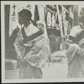 Utcai kép: két fiatalasszony kisdeddel a hátán