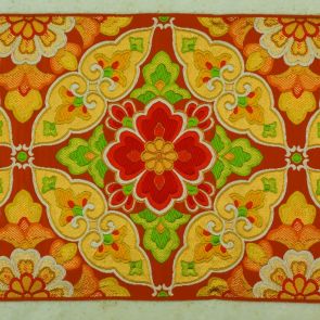 Japanese obi design sample with large white and golden abstract flower pattern (daikamon) in front of orange background, saganishiki brocading