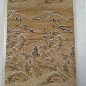 Textile sample - Landscape in black and brown weaving against a mustard yellow background