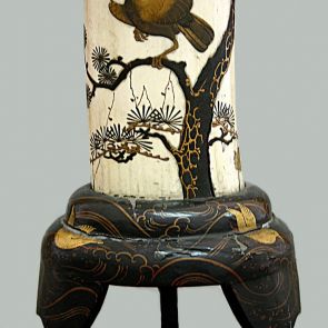 Brush container made from ivory, standing on a lacquered wooden pedestal, decorated with inlay and a prayer bird sitting on a pine tree