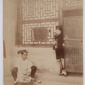 Unknown: An older Manchu lady smoking a pipe while washing, and a younger woman