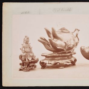 Photo of three bronze objects mounted on cardboard