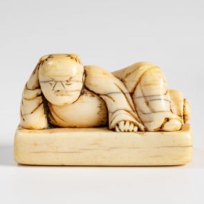 Netsuke in the form of a stamp: Karako lying on a brick-shaped base, resting on one elbow