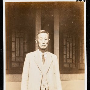 Öltönyös japán úr a ház előtt (a múzeum igazgatója?), Okura Shukokwan