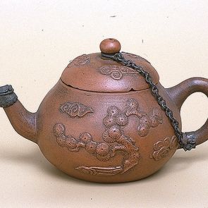 Pear-shaped teapot decorated with a pine tree and a dragon flying among clouds