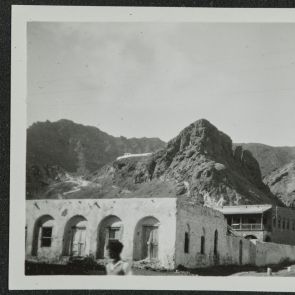 Flat-roofed houses at the foot of barren rocky mountains