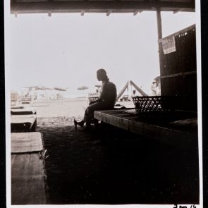 Woman in a kimono in the shade of an open pavilion on the beach