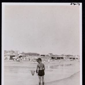 Fiúcska kis merítőhálóval a strandon