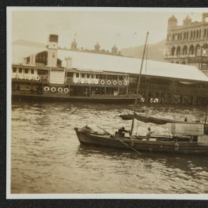 Houseboats in Hong Kong harbor, with European-style buildings in the background