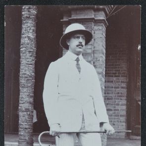 Szemüveges úr trópusi kalapban világos öltönyben