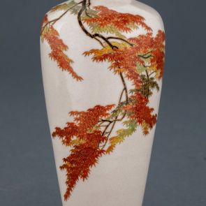 Vase with maple branches of autumn colours (momiji)