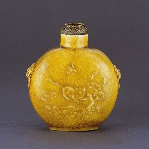 Snuff bottle with dark yellow glaze, decorated with floral and animal motifs