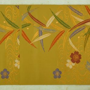 Japanese obi design sample with flowers and leaves in front of a dark golden background with undulating pattern (water)