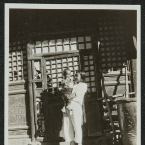 Young woman with her child in the courtyard of their house, Beijing