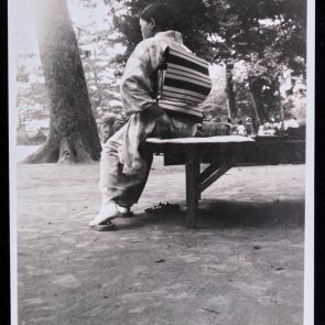 Pihenő hölgy egy parkban, csíkos obival átkötött kimonóban