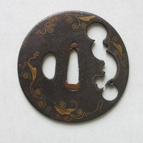 Round tsuba with irregular shaped openwork, with karakusa brass inlay of leaves and vines in Kaga zōgan